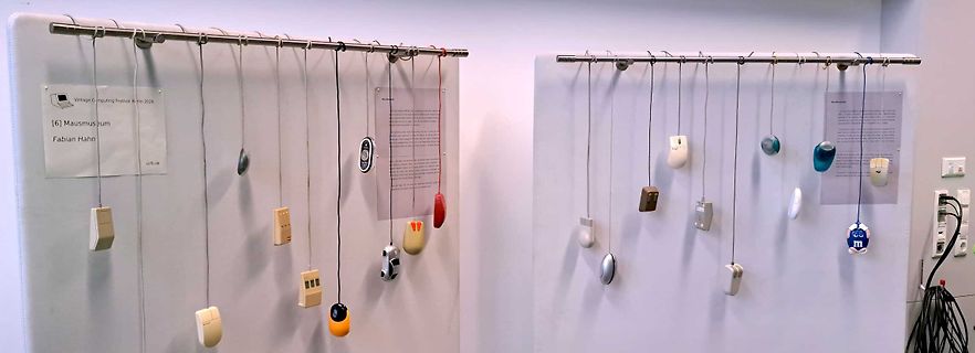 Ausstellung verschiedener Computermaus-Modelle an einer Wand