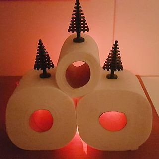 Drei Toilettenpapierrollen mit Tannenbaum-Dekoration