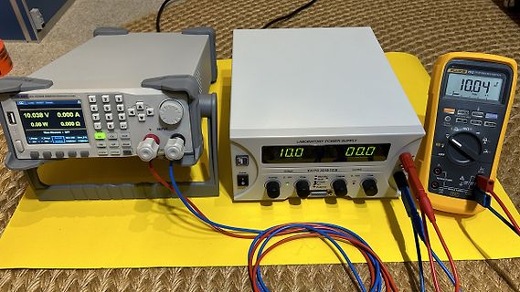 Elektronische Messgeräte und Labornetzteil auf gelbem Untergrund