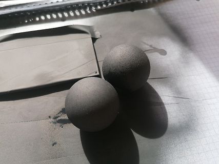 Zwei graue Kugeln auf Papier