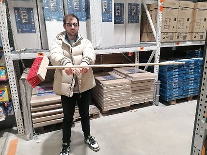 Mann hält Besen in einem Lagerhaus