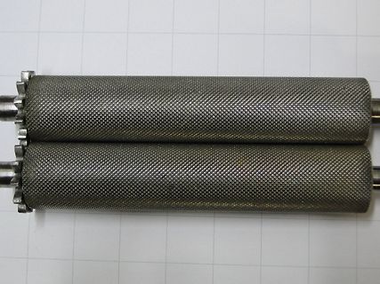 zwei metallische Walzen mit Riffelung