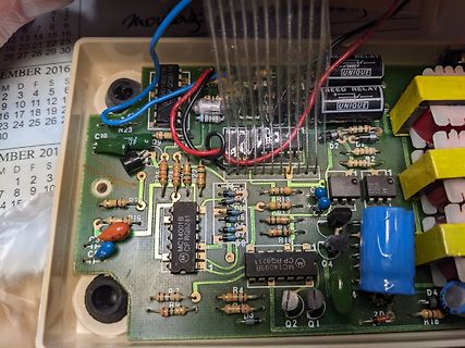 Geöffnete Elektronikplatine mit Bauteilen und Kabeln