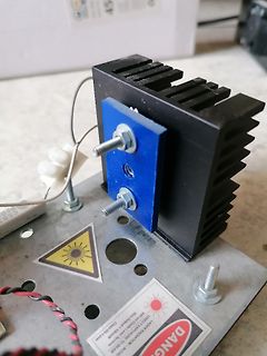 Aufbau eines Lasers mit Kühlkörper und Warnaufkleber