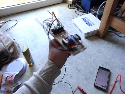 Hand hält elektronischen Aufbau mit Kabeln und Platine