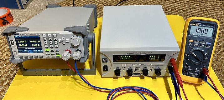 Elektronische Messgeräte und Labornetzteil auf gelbem Untergrund