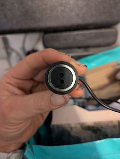 Hand hält einen runden Stecker oder Anschluss