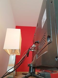Rückseite eines Monitors mit Kabeln und Lampe