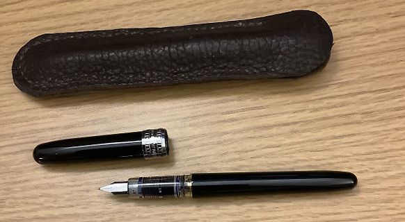 Füllfederhalter und Etui auf Holztisch