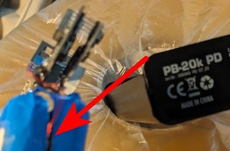 Elektronikbauteile und Powerbank mit rotem Pfeil