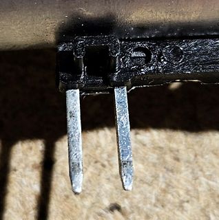 Nahaufnahme von zwei Metallstiften an einem schwarzen Kunststoffgehäuse