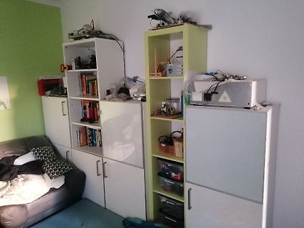 Werkstattregal mit Elektronikgeräten und Büchern
