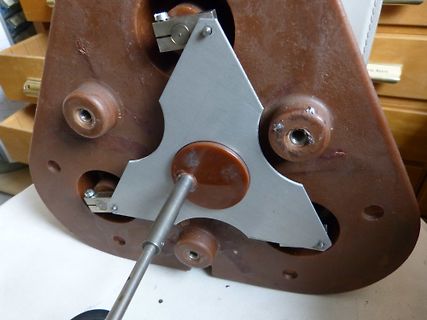 Mechanische Bauteile und Metallplatte auf braunem Gehäuse