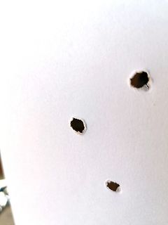 Drei Löcher in weißem Papier
