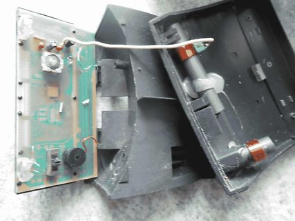 Geöffnetes elektronisches Gerät mit Platine und Gehäuseteilen