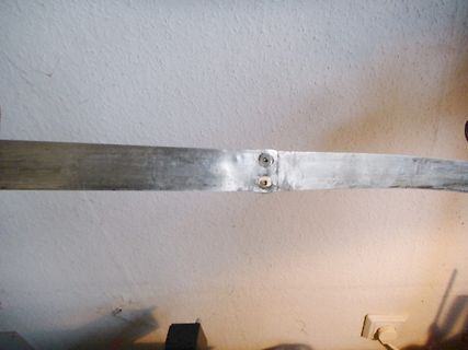 Metallstreifen mit zwei Schrauben an einer Wand