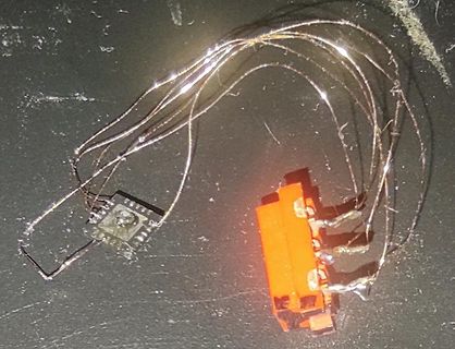 Freiverdrahtung mit Mikrocontroller und orangefarbenem Bauteil