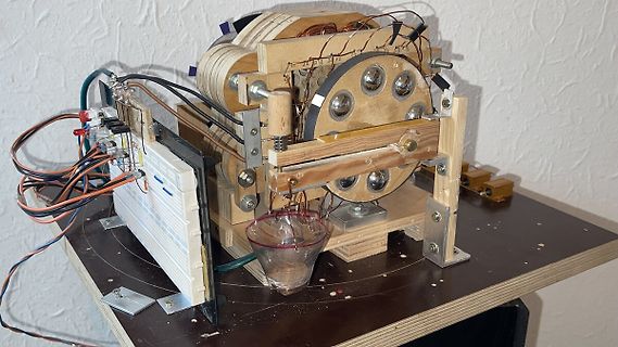 Experimenteller Aufbau mit Holzrahmen, Kabeln und Glasbehälter