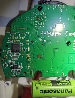 Grüne Leiterplatte mit elektronischen Bauteilen und Batterie