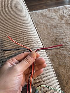 Hand hält mehrere bunte Kabel