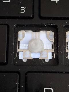 Defekte Laptop-Taste mit freigelegtem Mechanismus