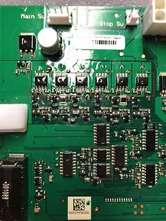 Nahaufnahme einer grünen Leiterplatte mit elektronischen Bauteilen