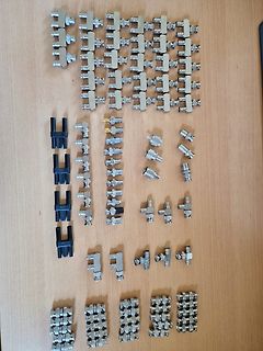 Vielzahl an metallischen Klemmen und Steckverbindern auf Holzuntergrund