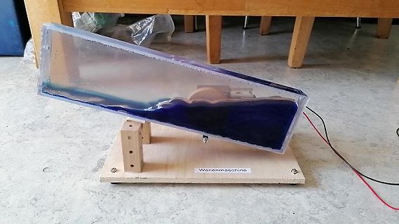 Wellenmaschine auf Holzsockel mit Flüssigkeit