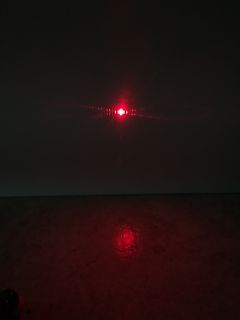 Roter Laserstrahl mit Beugungsmuster und Reflexion