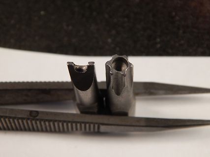 Metallische Bauteile in einer Pinzette