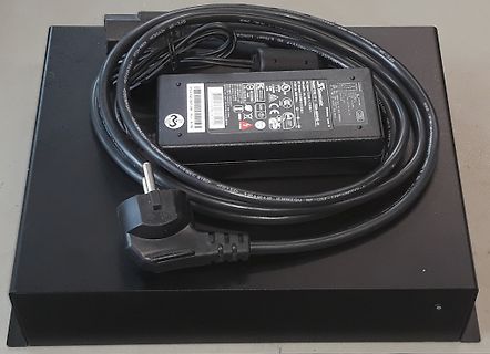 Netzteil mit Netzkabel auf schwarzem Untergrund