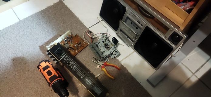 Zerlegtes Radio mit Werkzeug und Bohrmaschine