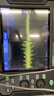 Abfotografiertes Handheld-Oszilloskop mit Signalverlauf