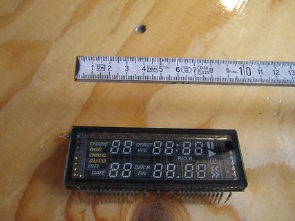 LCD-Display mit Maßband auf Holzuntergrund