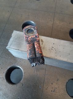 Beschädigter Metallanhänger oder Bauteil auf Werkstattplatte