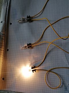 Drei leuchtende LEDs mit gelben Kabeln auf Millimeterpapier