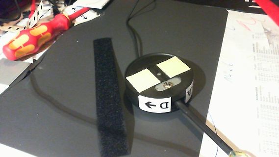 Elektronikbauteil mit Pfeilmarkierung und Schraube auf Tisch