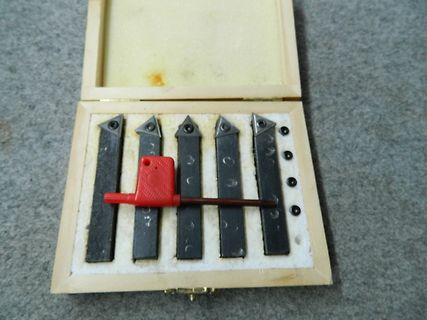 Set von Metallstiften in Holzschachtel mit rotem Werkzeug