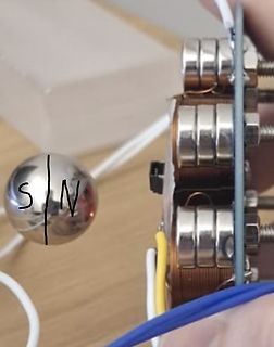 Nahaufnahme von Spulen und einem Metallkugel-Magneten