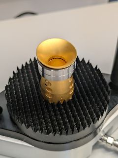 Goldfarbenes Bauteil auf schwarzem Spannfix
