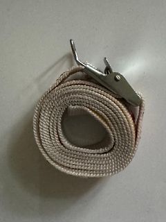 Aufgerolltes Gurtband mit Metallverschluss