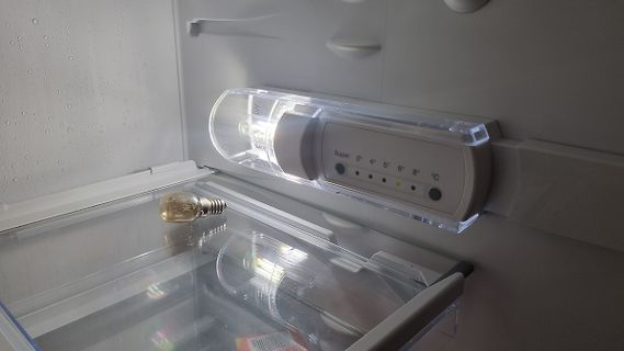 Glühbirne und Thermostat in einem Kühlschrank