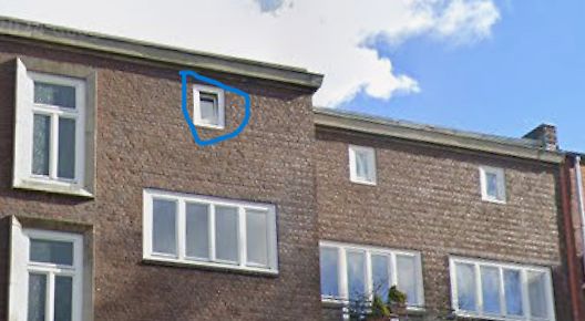 Außenansicht eines Backsteinhauses mit Fenstern