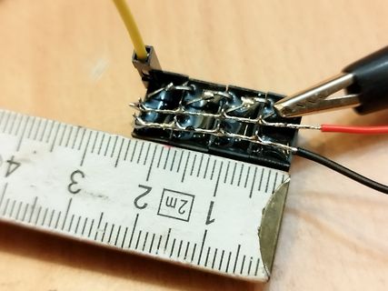 Lötstellen an einer Klemmenleiste mit Lineal und Messkabeln