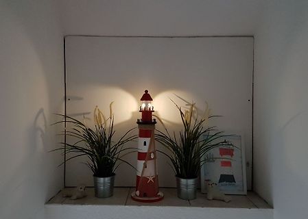 Leuchtturm-Dekoration mit Pflanzen und kleinen Roboterfiguren