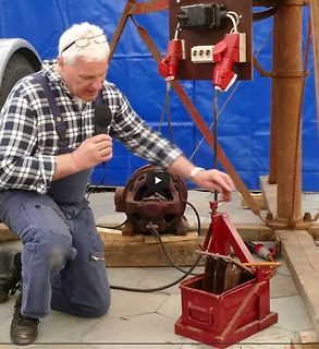 Mann mit Mikrofon vor elektrischem Aufbau