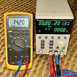 Multimeter und programmierbares Netzteil auf Werkstattunterlage