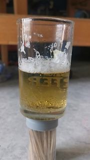 Glas mit Bier auf einem Behälter mit Zahnstochern