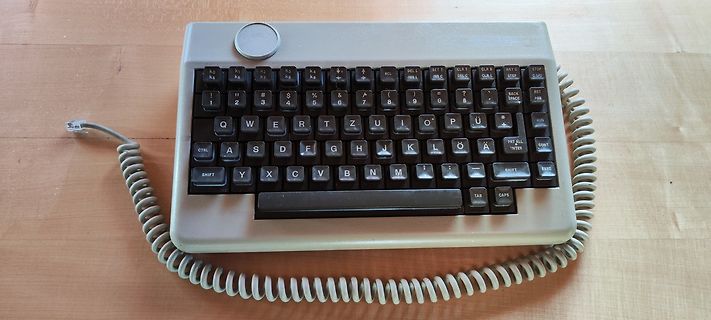 Retro-Tastatur mit Spiralkabel auf Holztisch