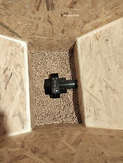 Schwarzes Bauteil in Holzspänen